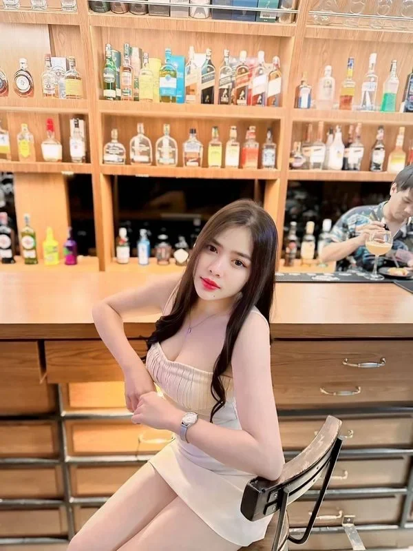 방콕 팟퐁 — 술병 진열장 앞 바에 앉은 여성